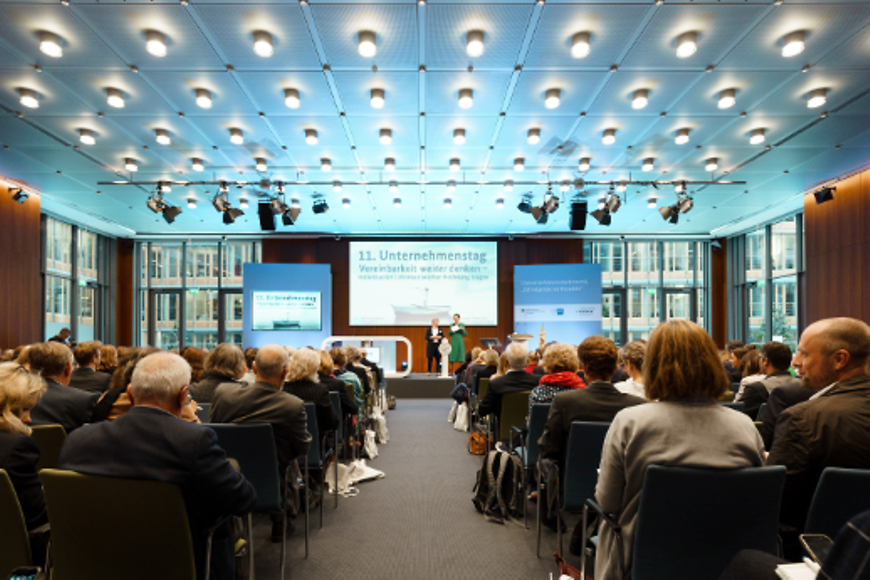 Zwei Frauen die einen Vortrag halten und ein Publikum