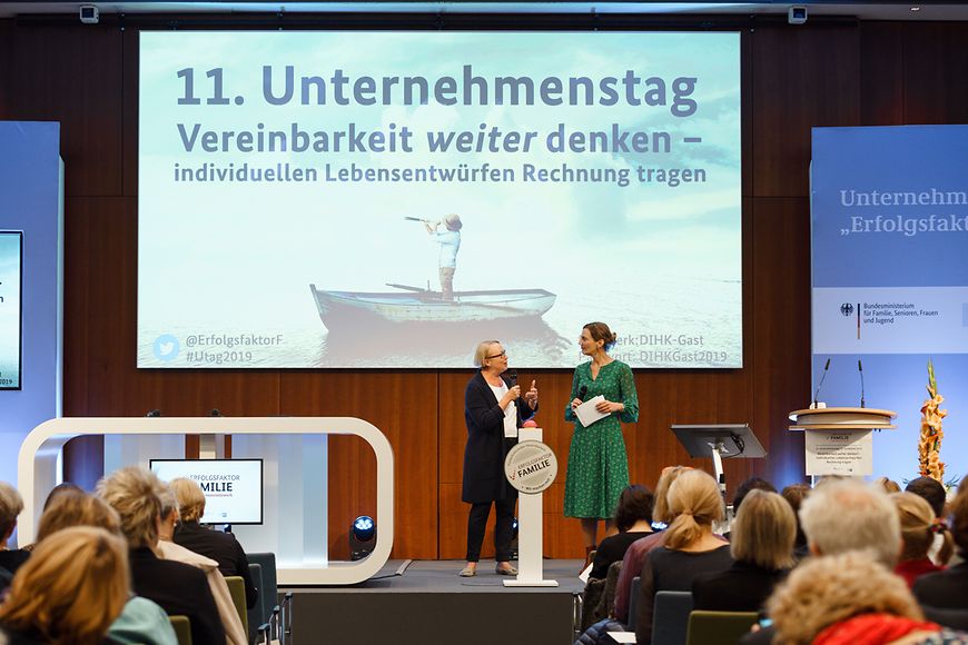 Zwei Frauen die einen Vortrag halten und ein Publikum